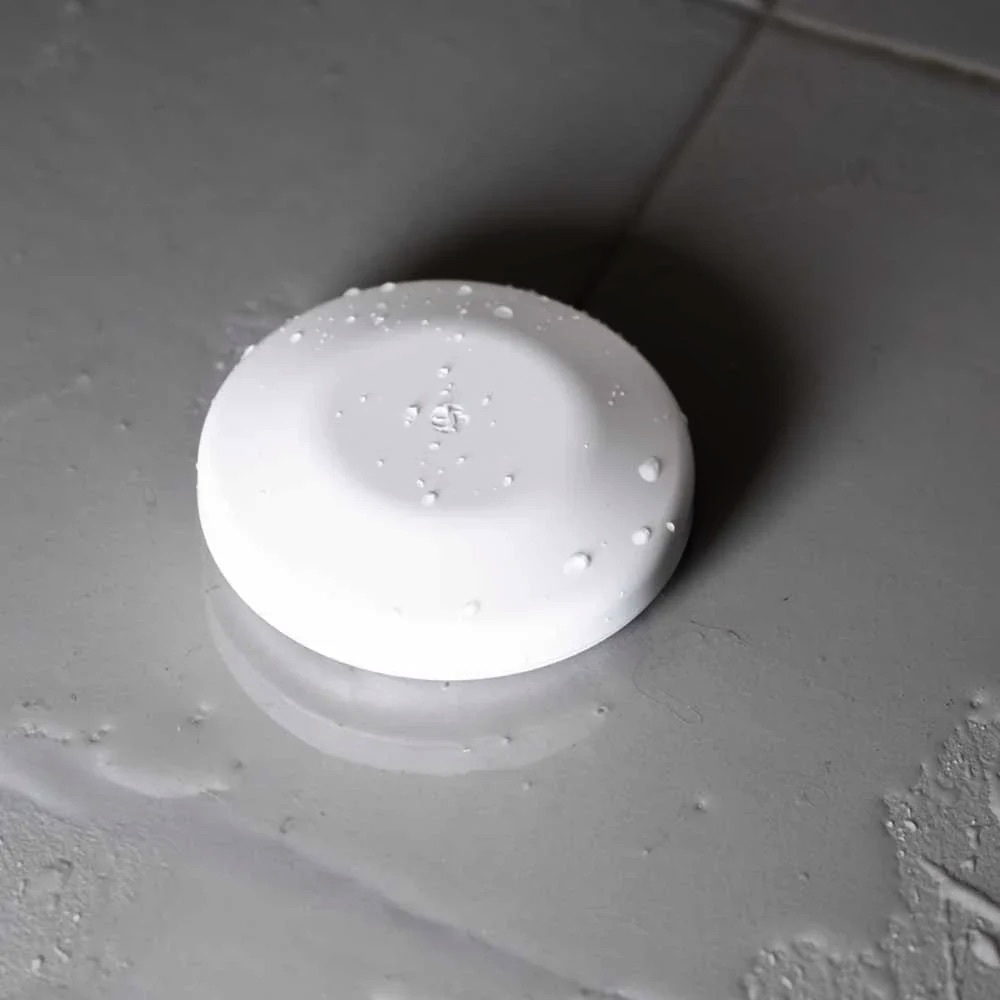 Shelly Flood S Gen4 water sensor on a tiled floor
